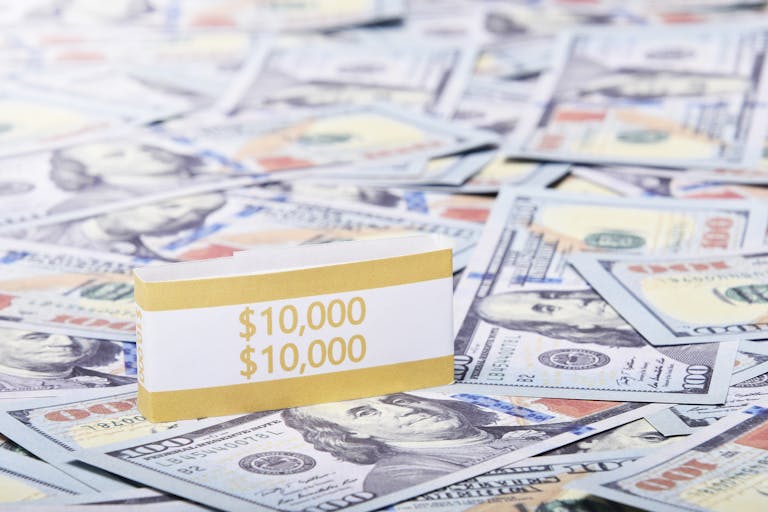 Close-up of a $10,000 stack of US dollars with a currency band, highlighting wealth and finance.